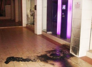 One man has been taken into custody for setting fire to tires in front of Siam Commercial Bank opposite Soi Town & Town. Another suspect is being sought.